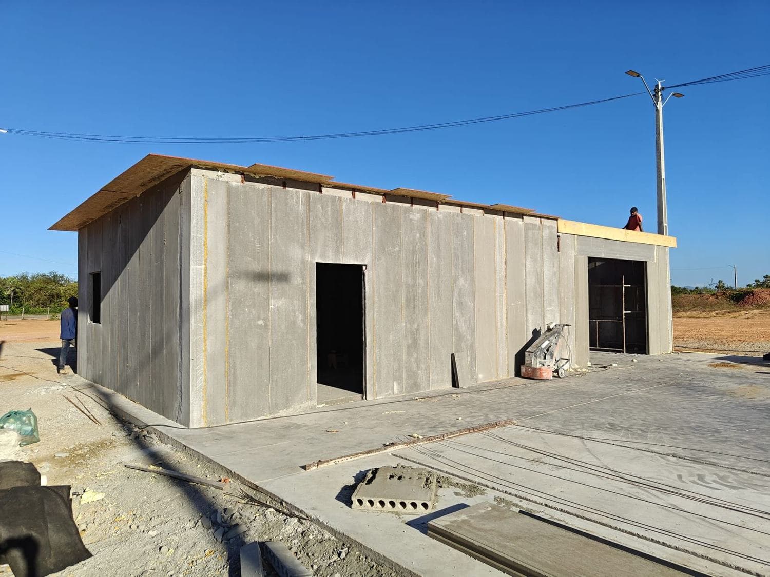 Estrutura de galpão concluída em painéis de concreto sob céu aberto.